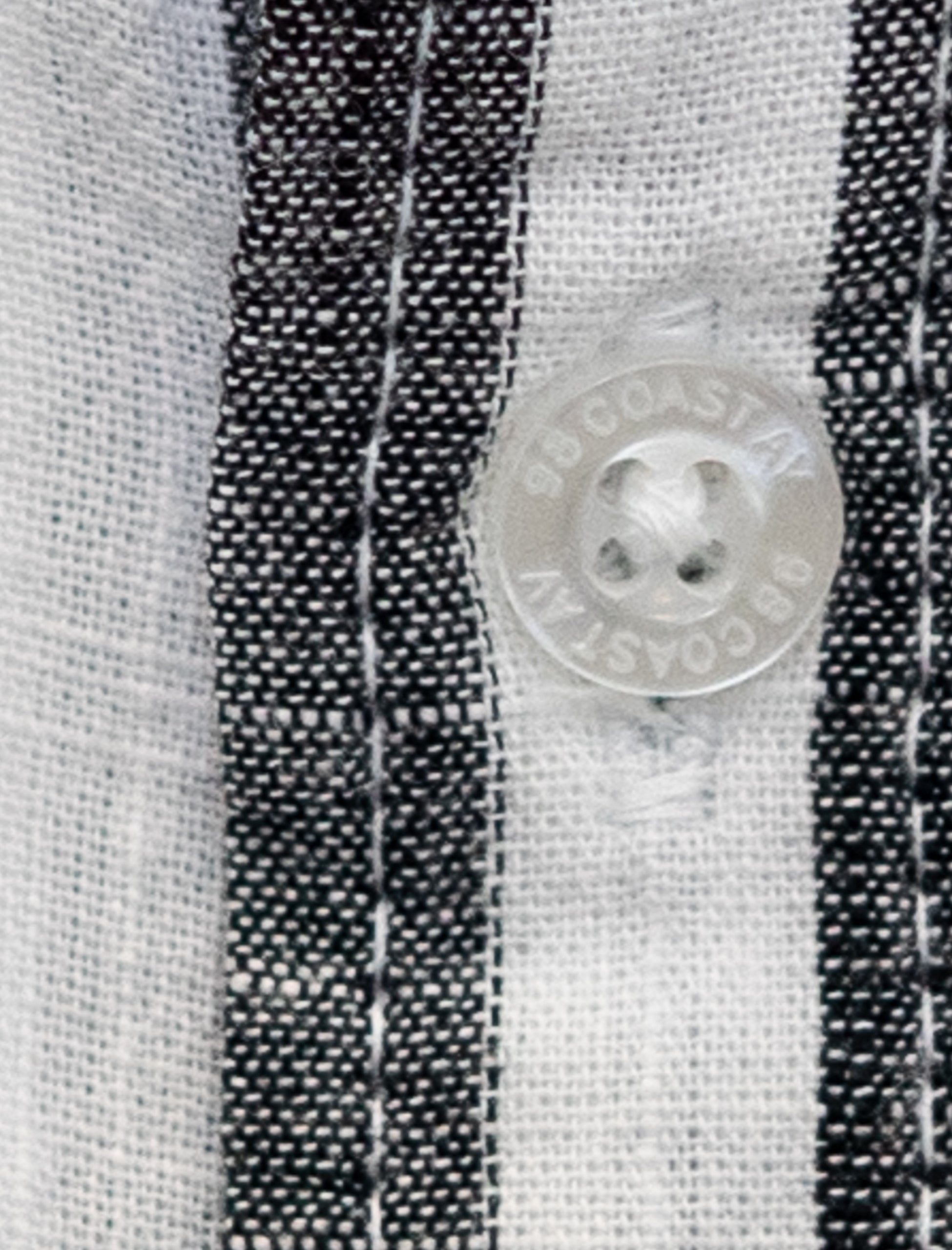 Detalle de la textura y botón en camisa rayada negro para niño