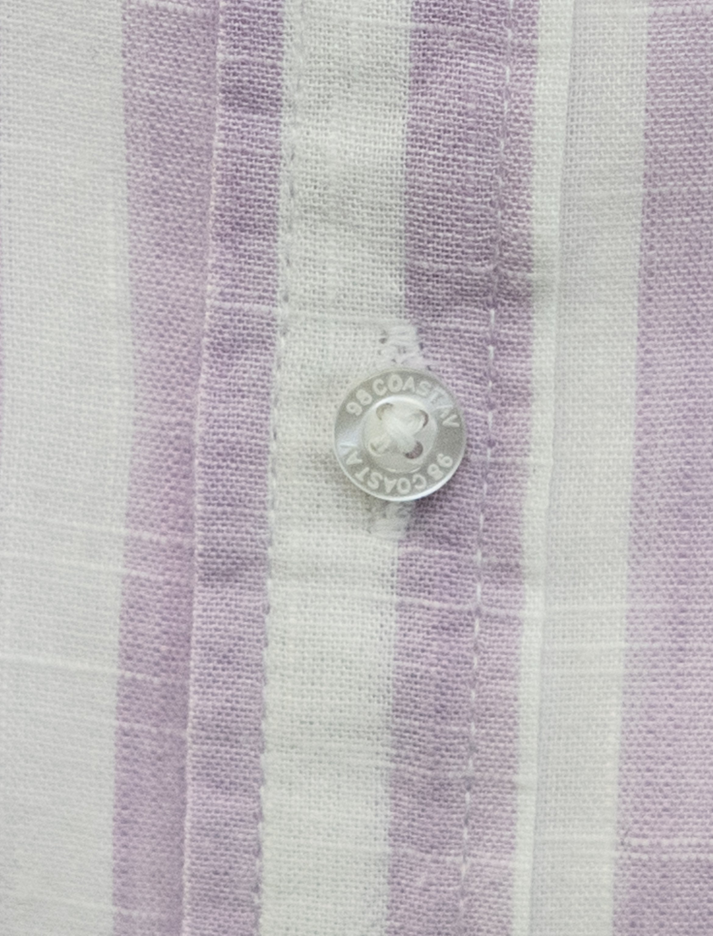Detalle de textura y botón en camisa rayada lila para niño