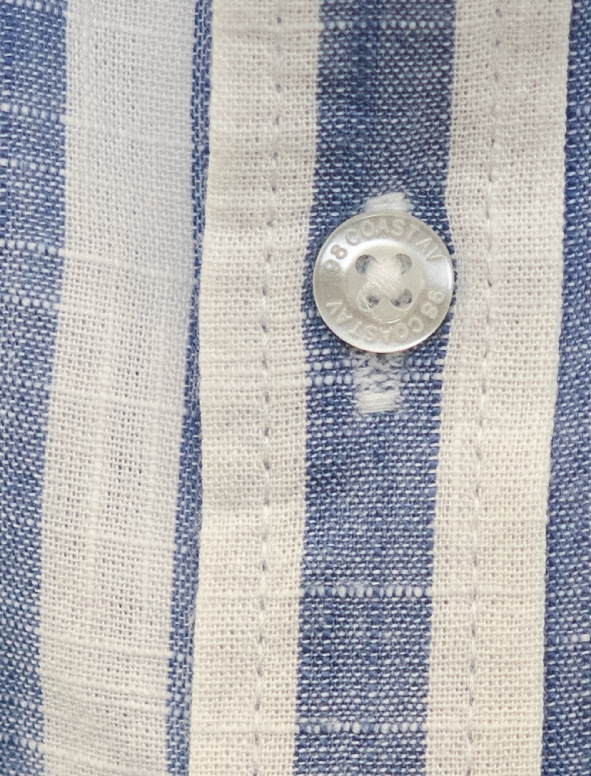 Detalle de la textura y botón en camisa rayada azul para niño