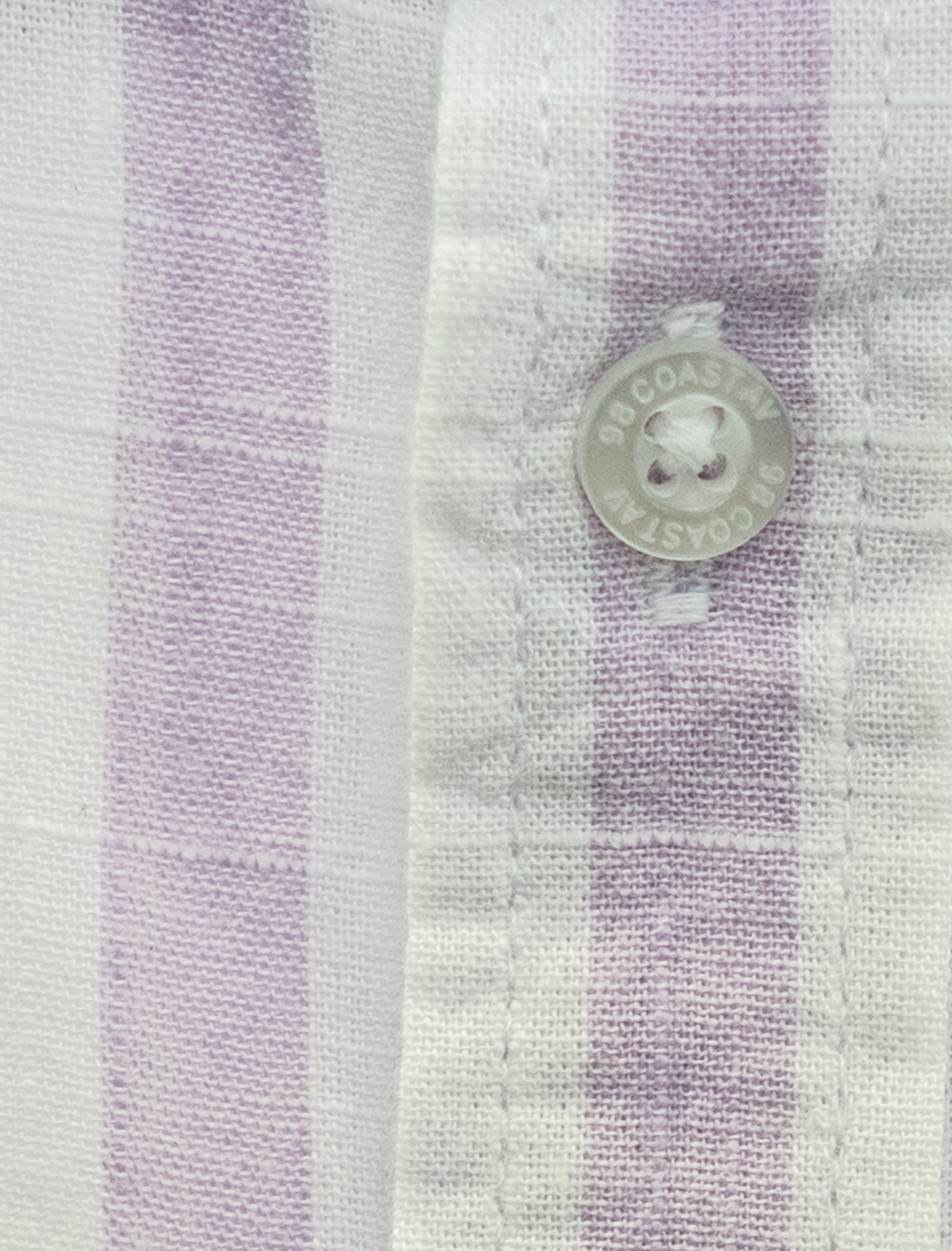 Detalle de la textura y botón en camisa rayada lila para niño