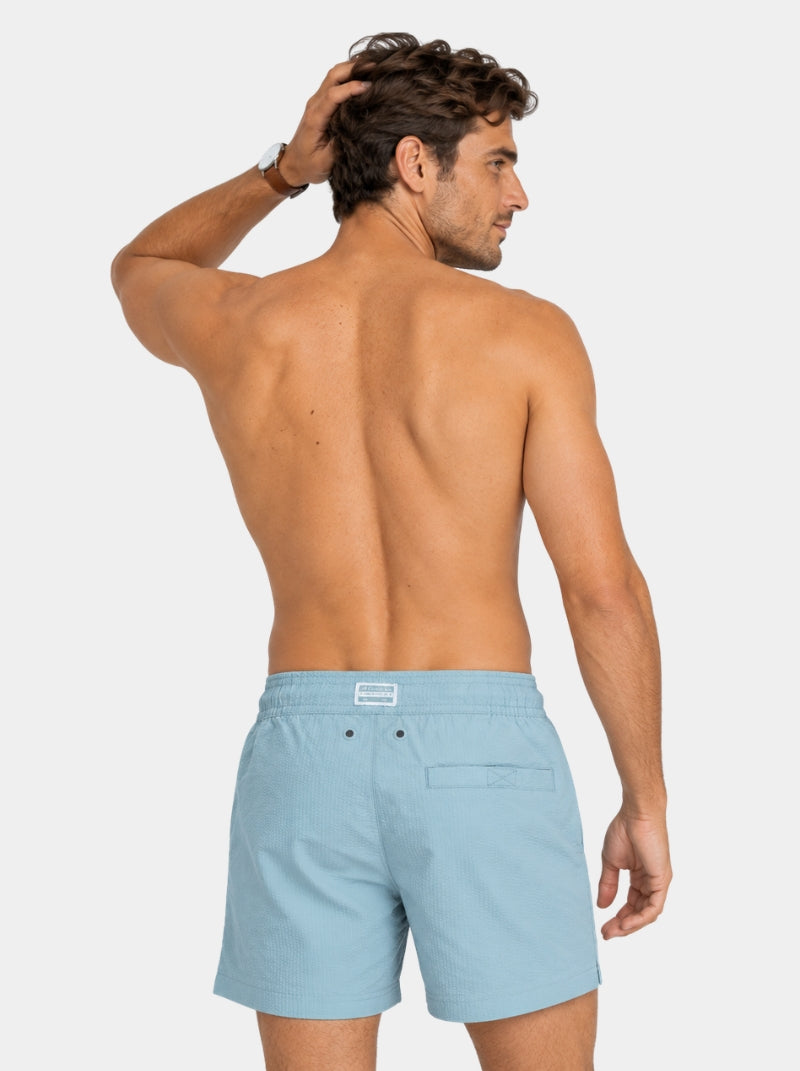 Short de baño Seersucker Capri azul claro para hombre, vista posterior con ojillos traseros - 98 Coast Av