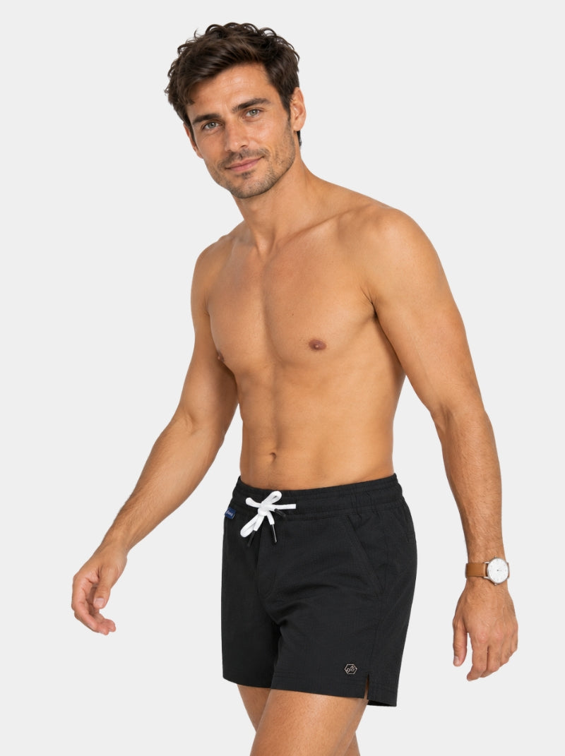 Short de baño Seersucker Capri negro para hombre, vista lateral con hexágono de logo metálico - 98 Coast Av