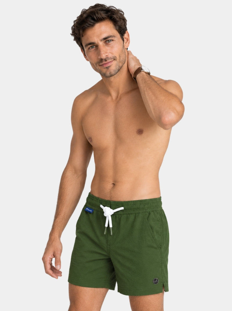 Short de baño Seersucker Capri olivo para hombre, vista lateral con hexágono de logo metálico - 98 Coast Av